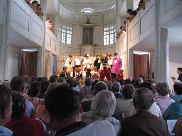 Kirchenschiff mit Bühne im Hintergrund und Publikum